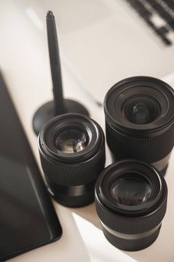 Beyaz masa üzerinde farklı asal lensleri olan fotoğrafçı işyeri