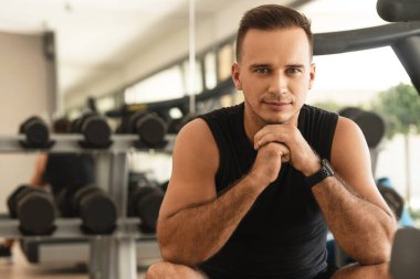 Spor salonunda spor kıyafetleri giyen yakışıklı bir adamın portresi.
