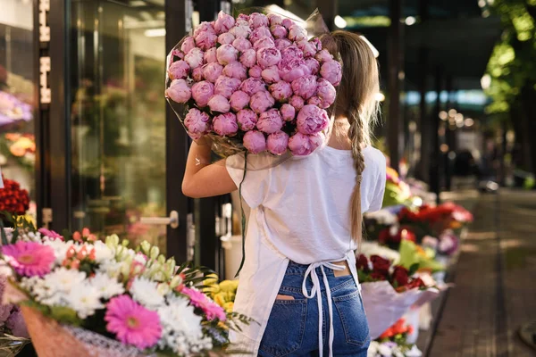 Fiatal Virágárus Egy Halom Rózsaszín Bazsarózsa Virágok Kis Virágüzlet — Stock Fotó