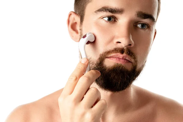白い背景でより良いひげの成長のためのメソローラーを使用してハンサムな男 — ストック写真