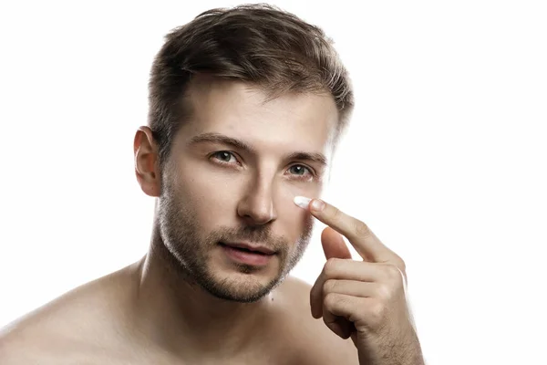 男人的美3 年轻男子在白种人的脸上涂了润肤抗老化霜 — 图库照片