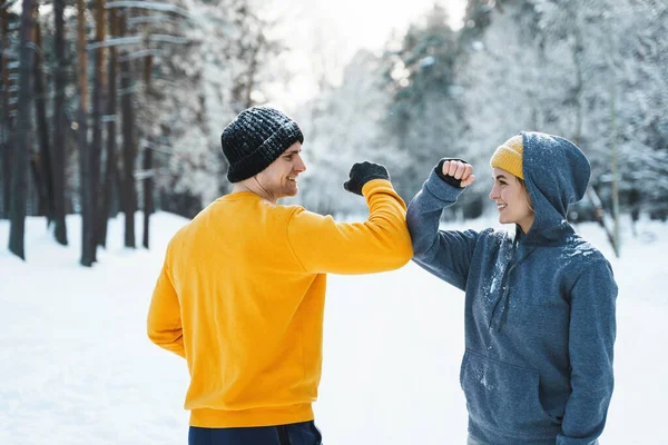 Dwóch Biegaczy Wita Się Łokciem Podczas Zimowego Treningu Zewnątrz — Zdjęcie stockowe