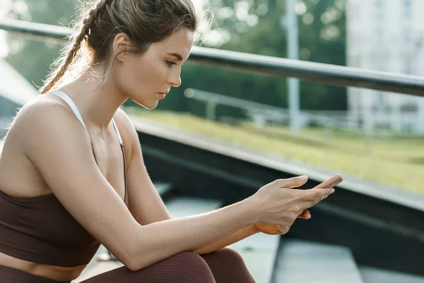 Wanita Atletik Muda Menggunakan Smartphone Selama Latihan Fitness Luar Ruangan — Stok Foto