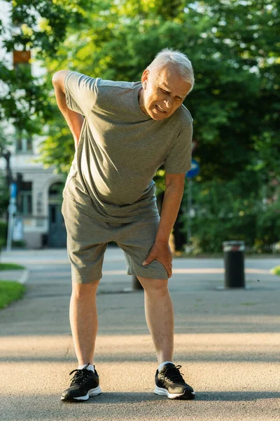 Starszy Mężczyzna Cierpiący Ból Dolnej Części Pleców Podczas Treningu Joggingowego — Zdjęcie stockowe