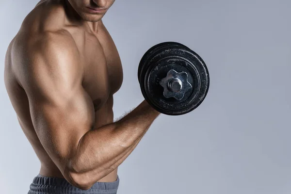 Homem Fisiculturista Jovem Muscular Trabalhando Com Halteres Fundo Cinza — Fotografia de Stock