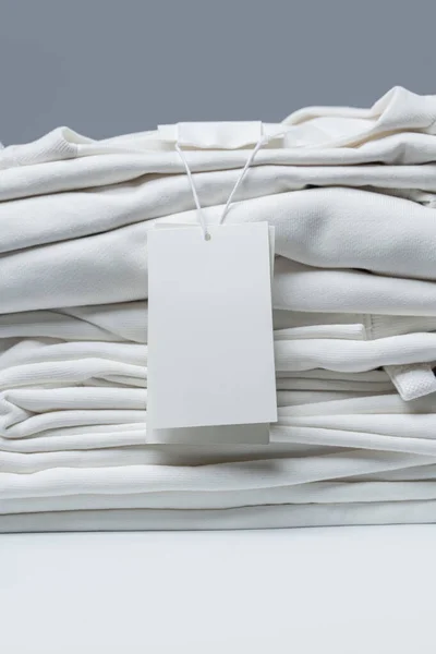 Пачка Новой Белой Одежды Пустой Биркой Сером Фоне — стоковое фото