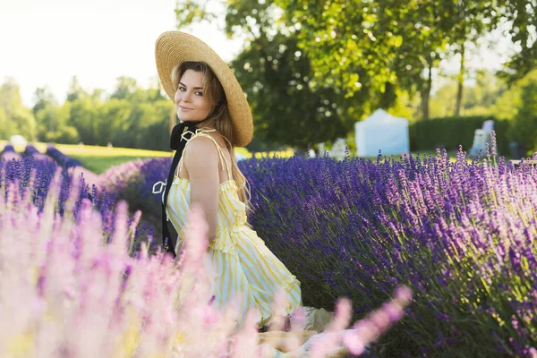 ラベンダーの花でいっぱいの分野で美しい若い女性の肖像画 — ストック写真