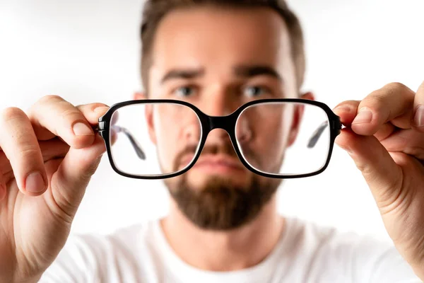Beyaz Arka Planda Gözlük Tutan Genç Bir Adam — Stok fotoğraf