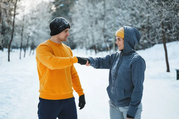 Dwóch Biegaczy Wita Się Gestem Uderzenia Pięścią Podczas Zimowego Treningu — Zdjęcie stockowe