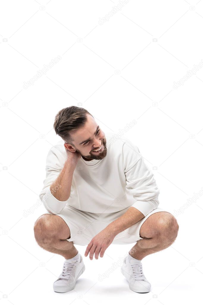 Handsome man wearing white sweatshirt and shorts isolated on white background