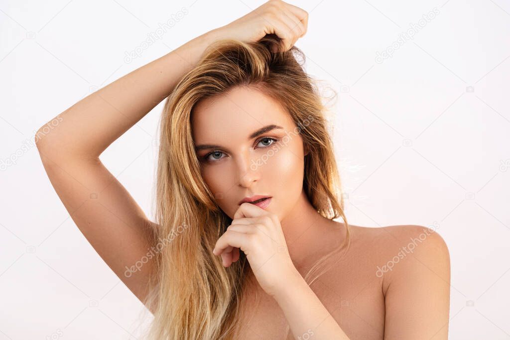 Portrait of young beautiful blonde woman with smooth skin in studio
