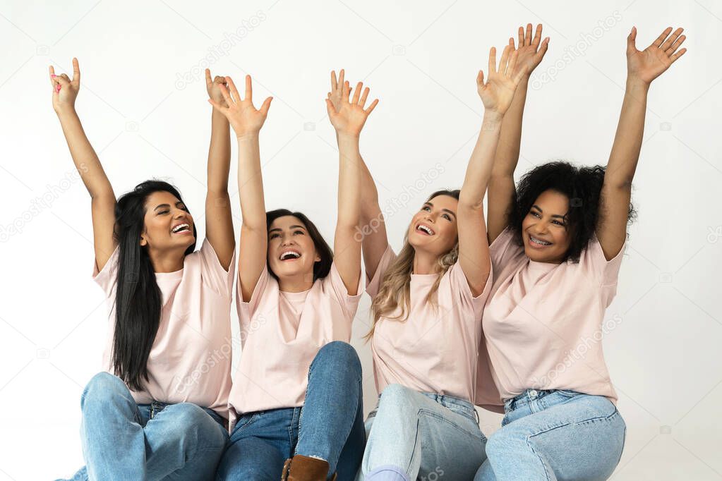 Multicultural diversity and friendship. Group of different ethnicity happy women raising hands