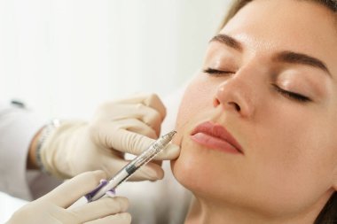 Estetik tıp kliniğinde yüz doldurma enjeksiyonları sırasında bayan istemci