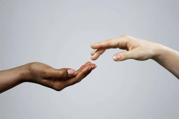 非洲和白人女性在灰色背景下的双手不同种族间的友谊 关爱和支持 — 图库照片
