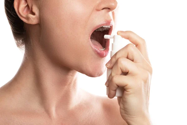 妇女在白色背景下使用止疼药来缓解喉咙痛 — 图库照片