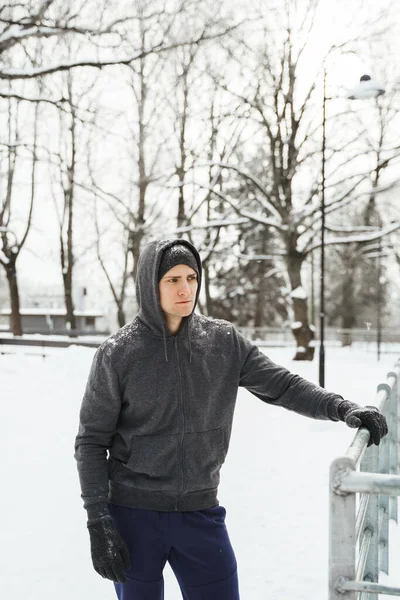 Portret Przystojnego Sportowca Kapturze Podczas Zimowego Treningu Zaśnieżonym Parku Miejskim — Zdjęcie stockowe