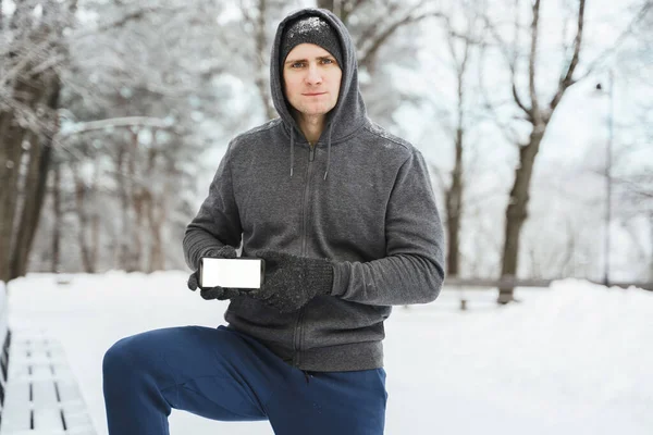 Jongeman Atleet Met Smartphone Met Een Leeg Scherm Tijdens Wintertraining — Stockfoto