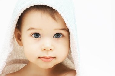Bebek hijyeni ve bakımı. Banyo yaptıktan sonra kapüşonlu havluya sarılı güzel gözleri olan tatlı bir çocuk. 