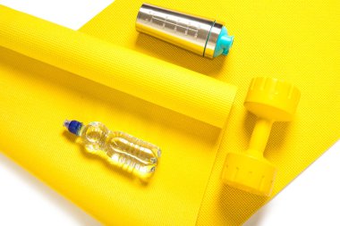 Üst düzey sarı dambıl, bir şişe su ve protein karıştırıcı.