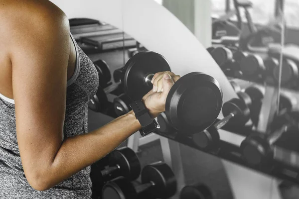 女运动员在健身房用哑铃进行健身时 — 图库照片