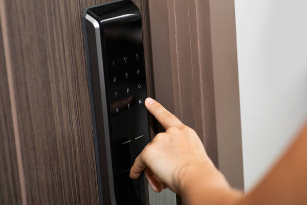 Female hand and digital smart code lock into the modern apartment