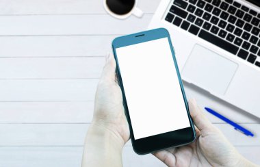 Ofis tarzı beyaz ahşap zeminde üst görünüm akıllı telefon ve bilgisayar defteri.