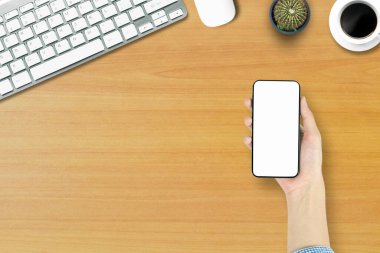 Ofis tarzı beyaz ahşap zeminde telefon bilgisayarının üstündeki en üst görünüm..