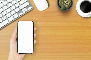 Ofis tarzı beyaz ahşap zeminde telefon bilgisayarının üstündeki en üst görünüm..