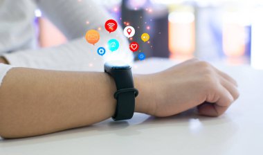 Kadın yenilikçi teknolojiyi kullanmak için akıllı bir saat kuruyor. Karışık ortam, dijital.