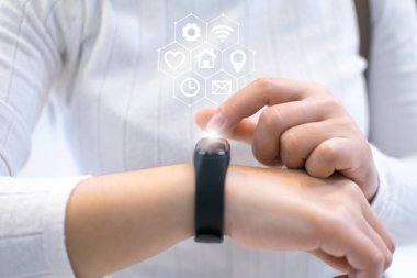 Kadın yenilikçi teknolojiyi kullanmak için akıllı bir saat kuruyor. Karışık ortam, dijital.