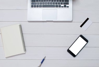 Ofis tarzı beyaz ahşap zeminde bilgisayar defterinin üstündeki üst görünüm.