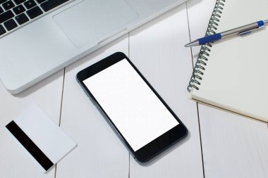 Beyaz ahşap zeminde ofis masası ve modern cep telefonu..