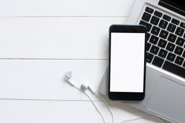 Ofis tarzı beyaz ahşap zeminde telefon bilgisayarının üstündeki en üst görünüm..