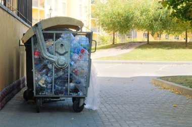 Plastik şişeler geri dönüşüm için bir konteynırda toplanır. Çöplükler çöplerle dolup taşıyor..