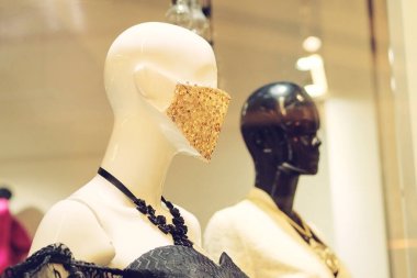 Moda maskeli bir manken bir giyim mağazasında Coperid 19 'a karşı duruyor. Büyük alışveriş merkezinde mankenler.
