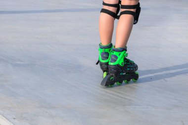 Boy riding on roller skates at outdoor skate park in city. Active urban life. Urban subculture. Copy space.
