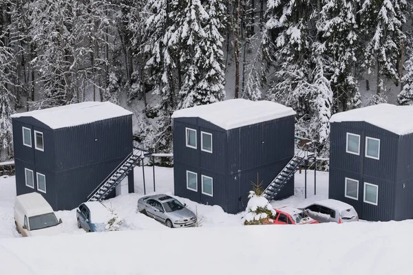 Modular houses in winter in the mountains. Modern cottagees in pine forest in winter. Tourist complex.