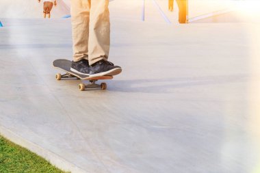 Güneşli bir günde kaykay parkında uzun sörf antrenmanı yapan patenciler. Aktif şehir hayatı. Şehir alt kültürü. Boşluğu kopyala.