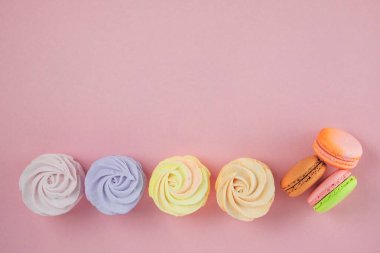 Tatil için geleneksel renkli tatlı tatlılar, fotokopi alanı. Tatlılar: yakın plan pembe arkaplanlı badem kurabiyeleri, şekerlemeler ve zephyrler. Üst görünüm.