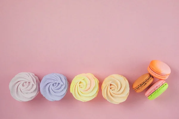 传统意义上的彩色甜食节庆 复制空间 粉红背景的金银花 棉花糖和锯子 顶部视图 免版税图库照片