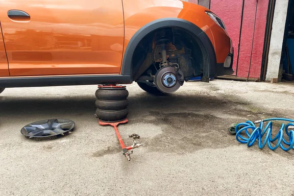 技师们在修理轮子 车轮平衡或修理和更换汽车轮胎 汽车维修概念 图库图片