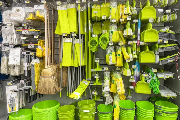 Tools for cleaning in the store. Shopping with background of green equipments on shelf in shop.