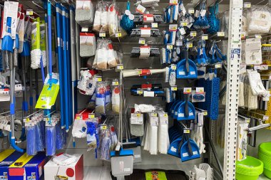 Dükkanda temizlik için aletler. Mağazadaki raflarda mavi ekipmanların arka planıyla alışveriş.
