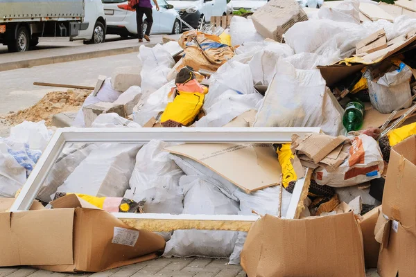 Construction debris in white bags prepared for disposal in a landfill. Bunch of trash. Removal of debris.