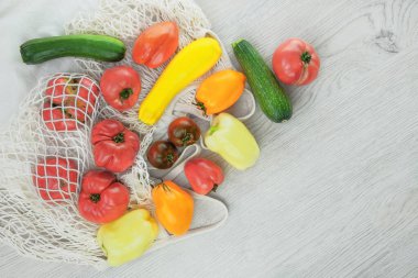 Çeşitli tarım domatesleri, biberler, beyaz ahşap arka planda kabak. Sıfır atık. Üst görünüm, alanı kopyala.