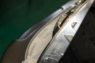 Bir oto tamirhanesinde araba farına takılmış bir lensin üst görüntüsü
