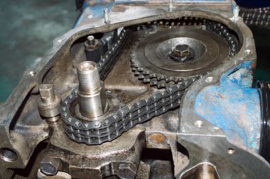 Bir otomobil içten yanmalı motorun kam mili sürücüsü bir oto tamir atölyesinde kısmen parçalanmış.