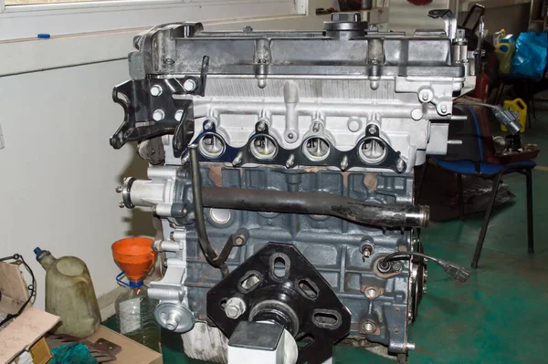 四缸汽车内燃机安装在汽车修理厂的发动机修理台上 — 图库照片
