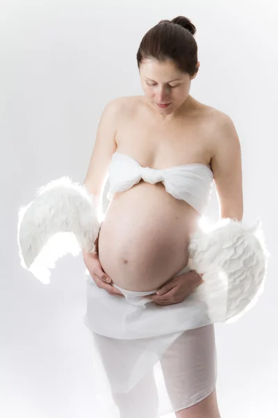 Gravidez. Mulher com asas ligadas à barriga . — Fotografia de Stock