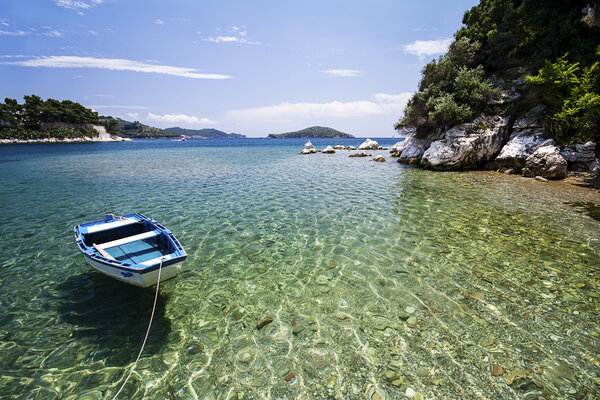 Moored boat near the beautiful cove, clear water.